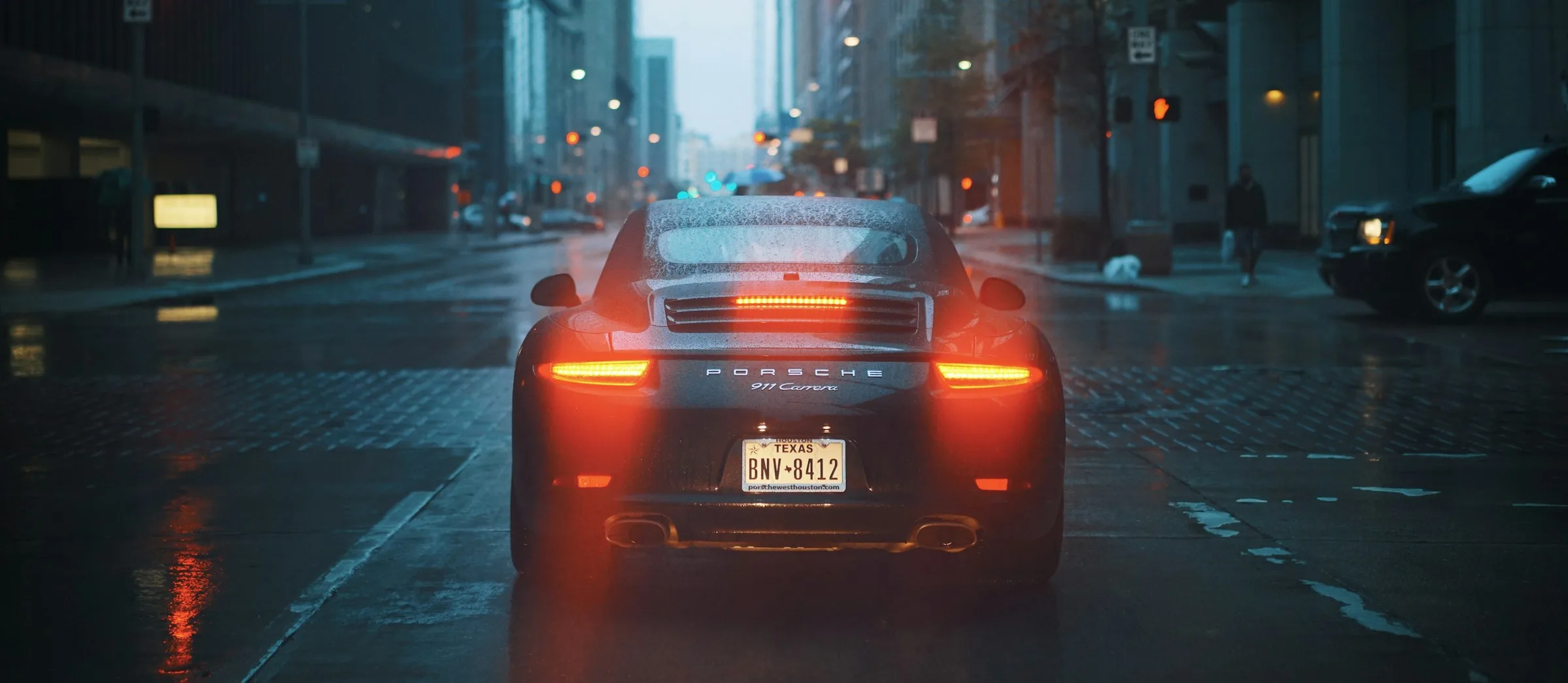 Sports car tail lights on a city street at dusk (illustrative)